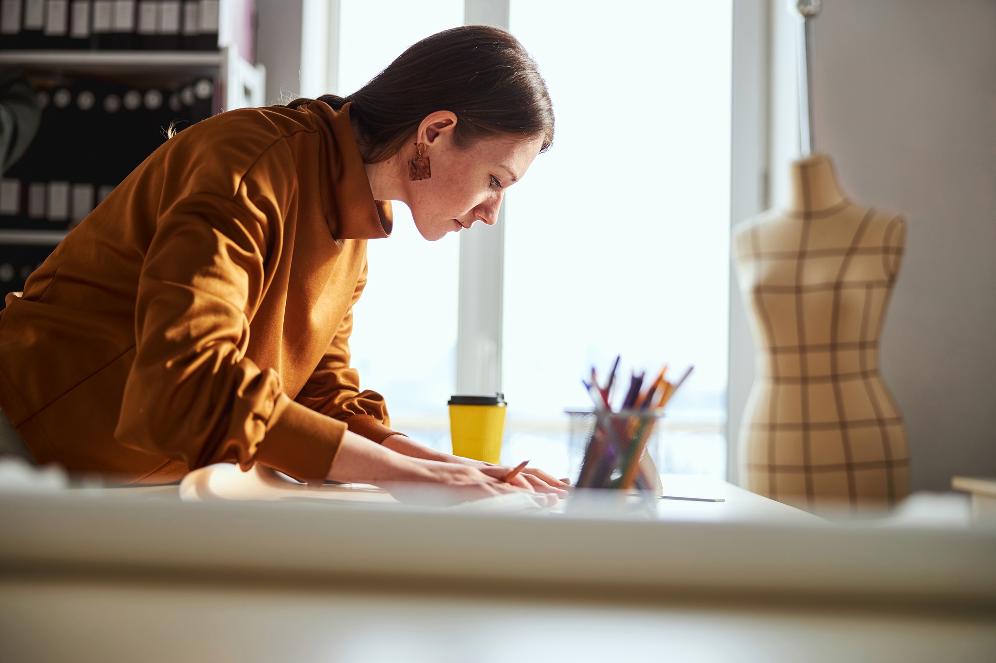 Dressmaker carefully placing ruler on square of paper